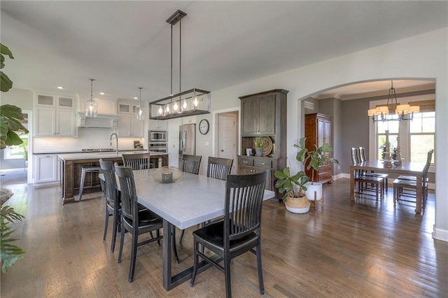 dining room with baseboards, arched walkways, dark wood-style floors, a chandelier, and recessed lighting