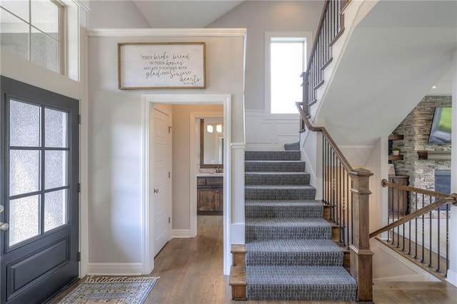 foyer entrance featuring stairs, a wealth of natural light, and wood finished floors