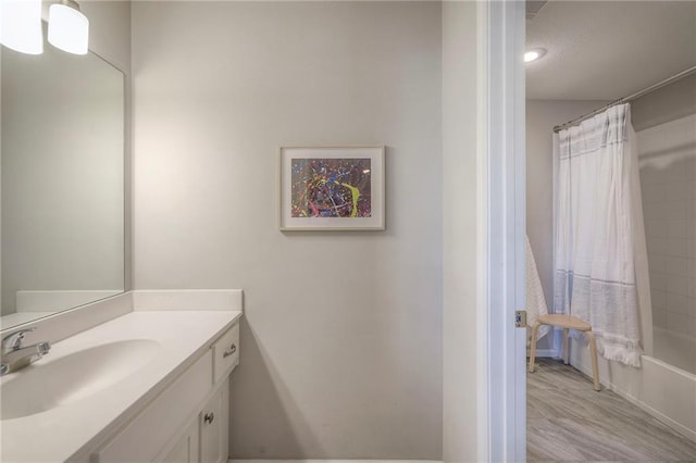 full bathroom featuring vanity, shower / tub combo, and wood finished floors