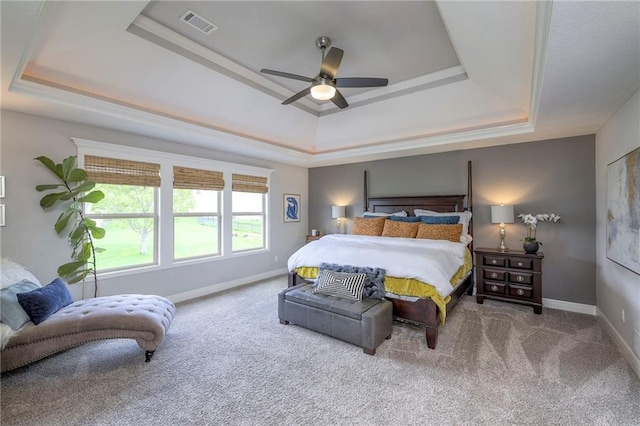 bedroom with a raised ceiling, carpet floors, baseboards, and visible vents