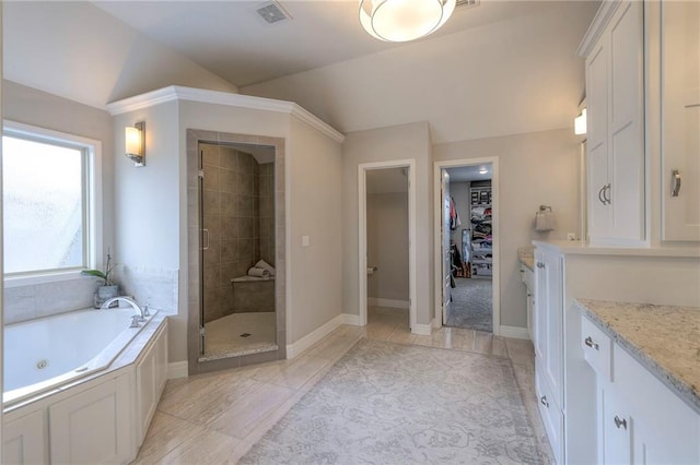 bathroom featuring lofted ceiling, a stall shower, visible vents, vanity, and a tub with jets