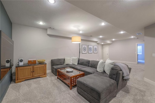 living room with a textured ceiling, light carpet, baseboards, and recessed lighting