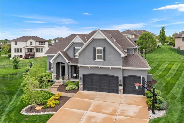 view of front facade featuring stone siding, an attached garage, stucco siding, fence, and a front lawn