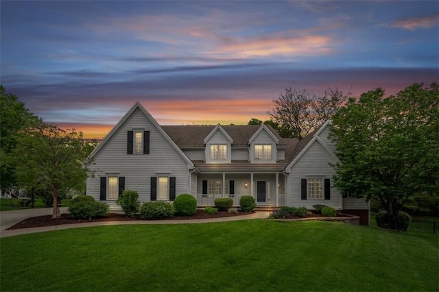traditional home with a porch and a lawn