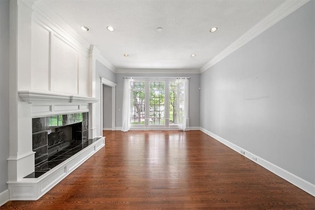 unfurnished living room featuring baseboards, ornamental molding, and wood finished floors