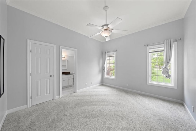 unfurnished bedroom featuring carpet floors, baseboards, ornamental molding, and ensuite bathroom