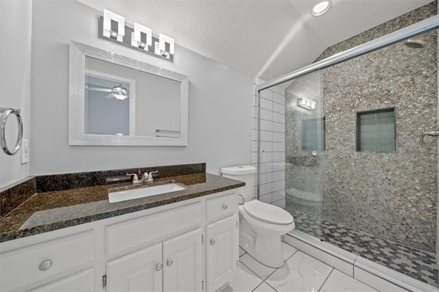 bathroom featuring a ceiling fan, vaulted ceiling, a stall shower, vanity, and toilet