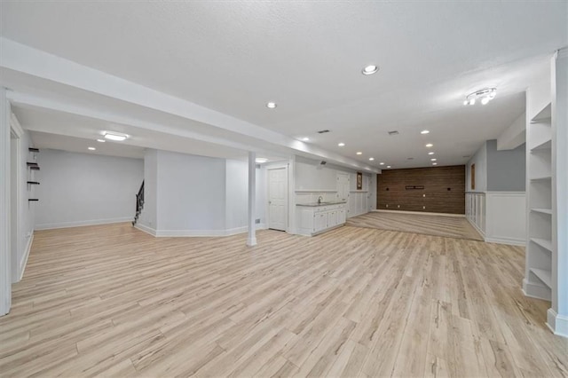 finished basement featuring baseboards, recessed lighting, and light wood finished floors