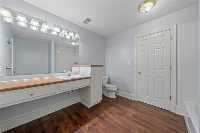 bathroom with visible vents, wood finished floors, vanity, baseboards, and toilet