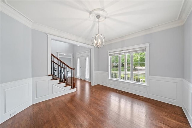 interior space featuring crown molding, wood finished floors, stairway, a wainscoted wall, and a chandelier