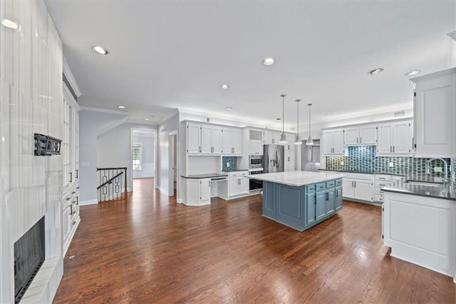 kitchen with white cabinets, recessed lighting, a sink, and stainless steel refrigerator with ice dispenser