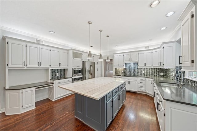 kitchen with a center island, dark wood-type flooring, white cabinets, gray cabinetry, and stainless steel appliances