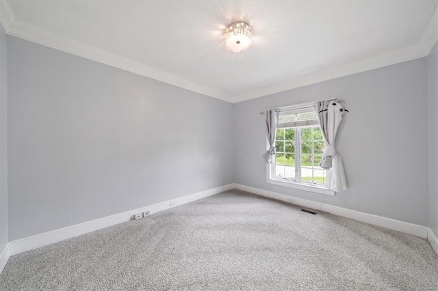 carpeted empty room with baseboards, ornamental molding, and visible vents