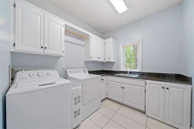 washroom featuring a sink, cabinet space, light tile patterned floors, and washer and dryer