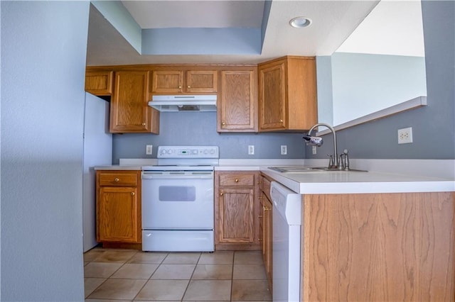 kitchen with white appliances, brown cabinetry, under cabinet range hood, light countertops, and a sink