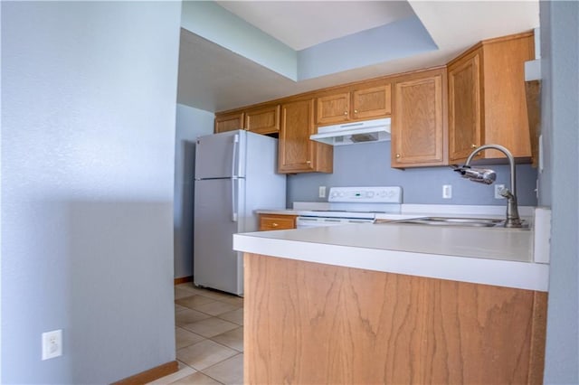 kitchen with white appliances, under cabinet range hood, light tile patterned flooring, light countertops, and a sink