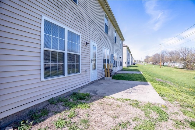 view of property exterior with a yard, a residential view, and a patio area