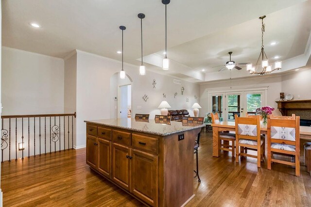 21287 W 116th St, Olathe, KS 66061 - kitchen featuring ceiling fan, dark wood-style flooring, arched walkways, ornamental molding, and brown cabinets