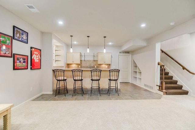 21287 W 116th St, Olathe, KS 66061 - kitchen featuring light carpet, recessed lighting, a kitchen breakfast bar, a peninsula, and pendant lighting