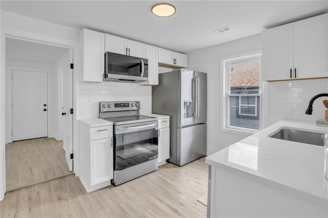 kitchen with light wood finished floors, visible vents, a sink, and appliances with stainless steel finishes