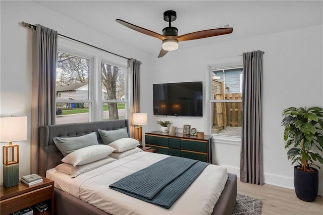 bedroom with baseboards, a ceiling fan, and wood finished floors