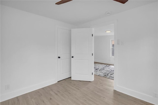 spare room with light wood-style flooring, ceiling fan, and baseboards