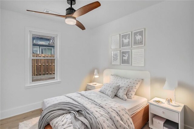 bedroom with wood finished floors, ceiling fan, and baseboards
