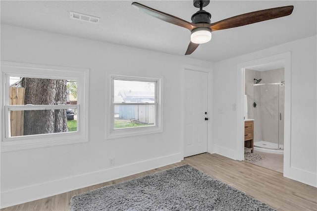 unfurnished bedroom with visible vents, light wood-type flooring, baseboards, and ensuite bathroom