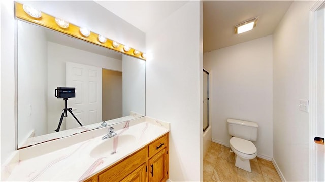 bathroom featuring toilet, baseboards, tile patterned flooring, combined bath / shower with glass door, and vanity