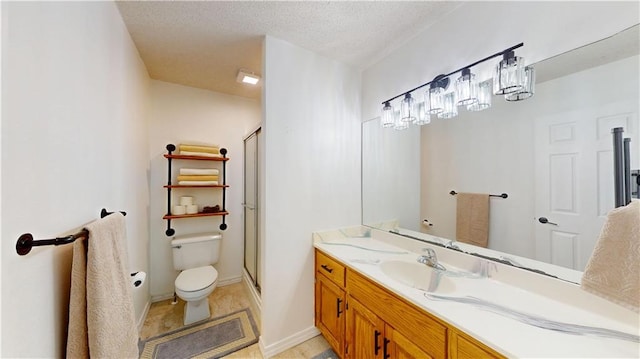 bathroom with vanity, a shower stall, and toilet