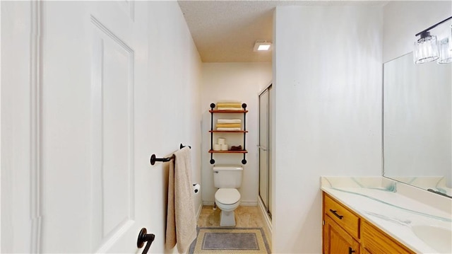 bathroom featuring toilet, a stall shower, tile patterned flooring, and vanity