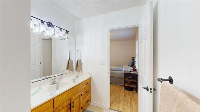 bathroom with wood finished floors, ensuite bath, and vanity