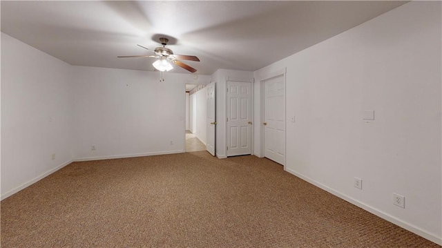 unfurnished room with light carpet, a ceiling fan, and baseboards