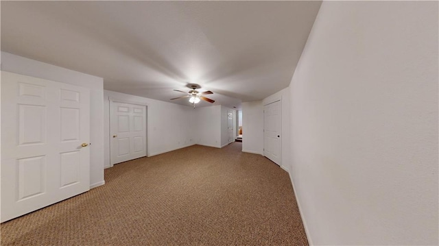 empty room with a ceiling fan, baseboards, and carpet
