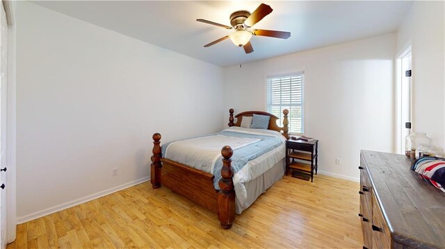 bedroom with light wood-type flooring, a ceiling fan, and baseboards