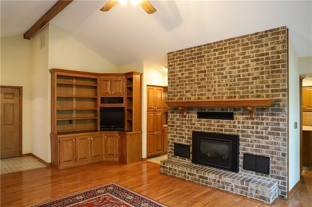 1203 E Quincy St, Pittsburg, KS 66762 - unfurnished living room featuring a fireplace, light wood-type flooring, a ceiling fan, and vaulted ceiling with beams