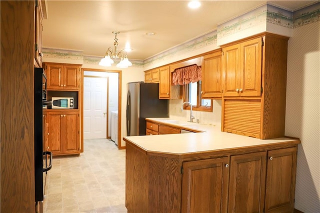 1203 E Quincy St, Pittsburg, KS 66762 - kitchen featuring a sink, brown cabinetry, white microwave, a peninsula, and washer / clothes dryer