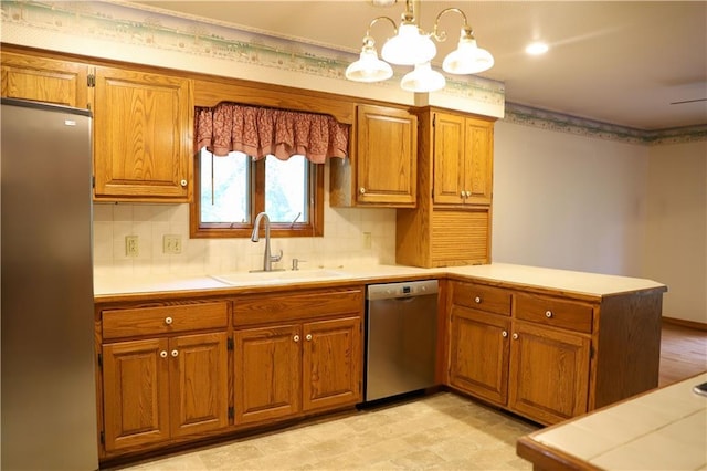1203 E Quincy St, Pittsburg, KS 66762 - kitchen featuring a sink, brown cabinets, stainless steel appliances, light countertops, and a peninsula