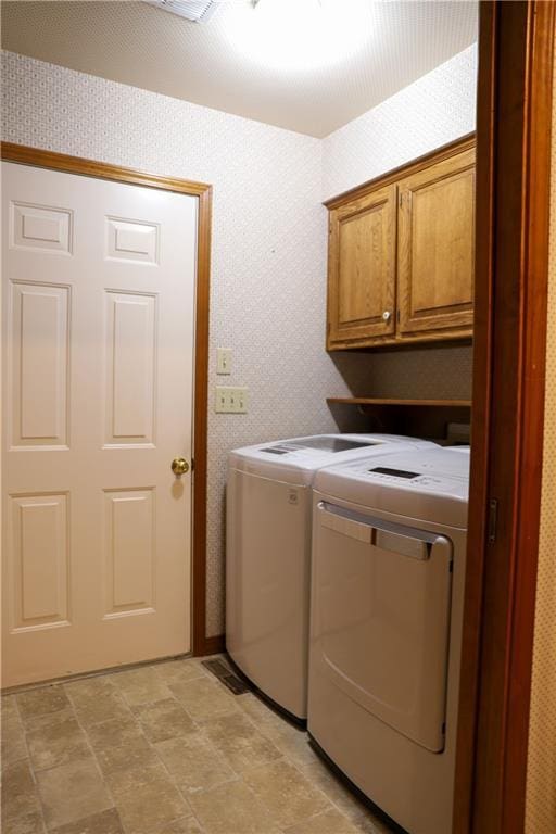 1203 E Quincy St, Pittsburg, KS 66762 - washroom with washing machine and clothes dryer, cabinet space, stone finish floor, and wallpapered walls