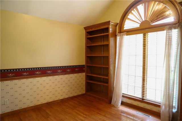 1203 E Quincy St, Pittsburg, KS 66762 - empty room with lofted ceiling, baseboards, visible vents, and light wood-style floors