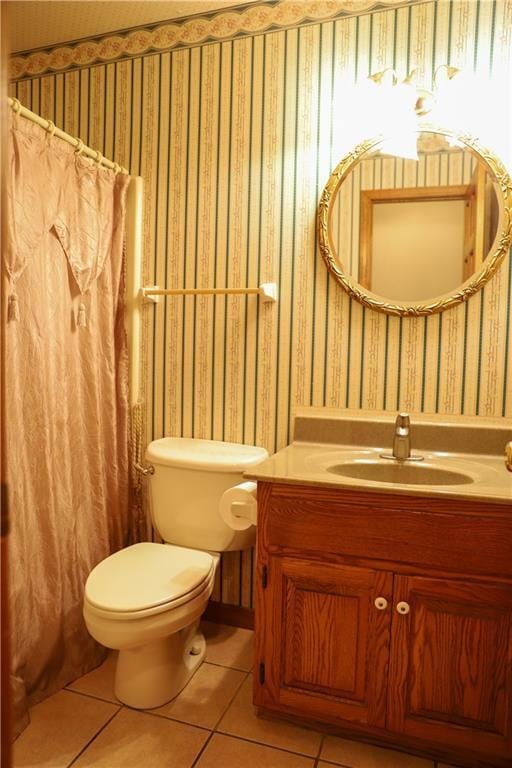 1203 E Quincy St, Pittsburg, KS 66762 - bathroom with tile patterned floors, a shower with curtain, toilet, wallpapered walls, and vanity