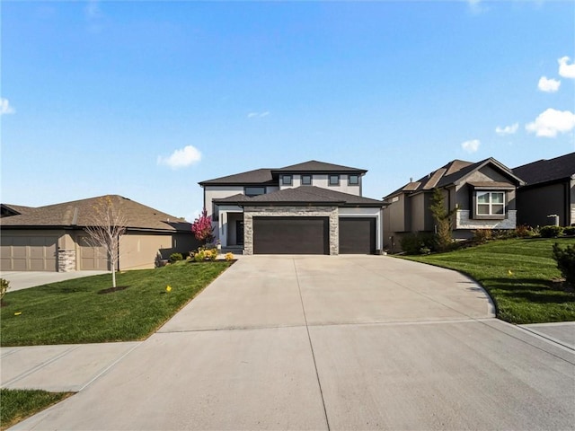 prairie-style home with concrete driveway, a garage, stone siding, and a front lawn