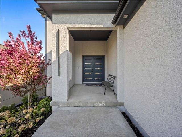 entrance to property featuring stucco siding