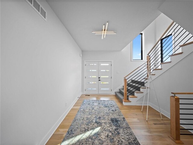 entryway featuring stairs, baseboards, visible vents, and french doors