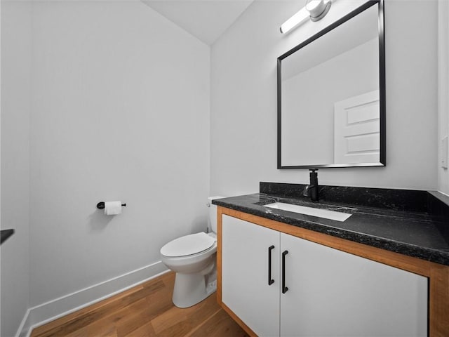 bathroom with vanity, baseboards, toilet, and wood finished floors