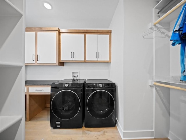 laundry room with separate washer and dryer, baseboards, cabinet space, and light wood-style flooring