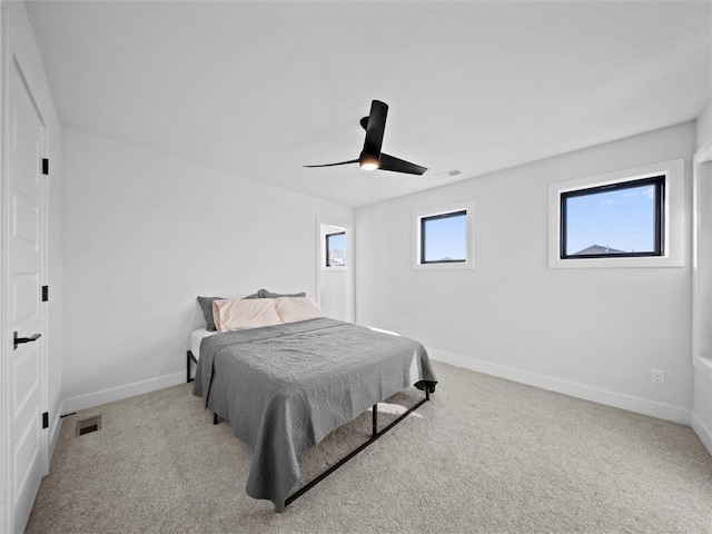 carpeted bedroom featuring baseboards, visible vents, and ceiling fan