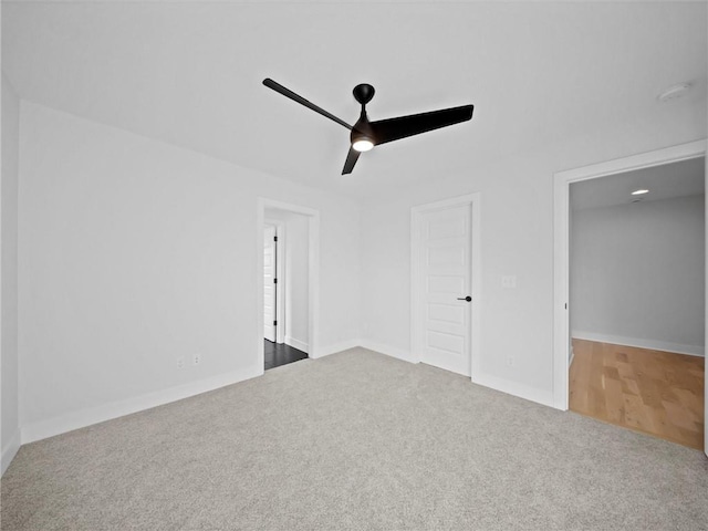 interior space with carpet flooring, a ceiling fan, and baseboards