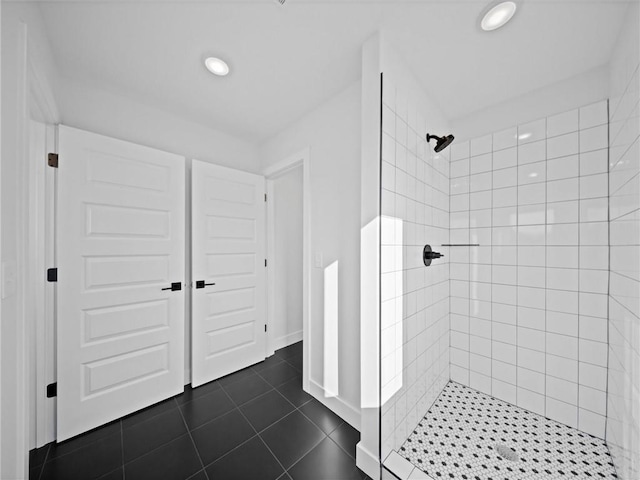 bathroom featuring recessed lighting, baseboards, tiled shower, and tile patterned flooring