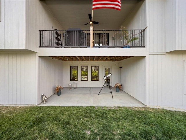 rear view of property featuring a lawn, a balcony, and a patio